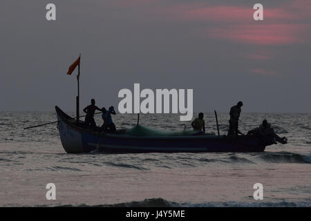 Silhouette eines Fischerbootes mit Männern Stockfoto