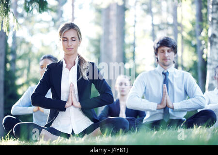 Business-Leute praktizieren Yoga im park Stockfoto