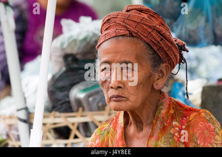 Alte Frau saß auf der Straße in Denpasar, Bali, Indonesien Stockfoto