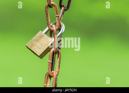 Gesperrt Konzept. Geschlossenes Vorhängeschloss um eine rostige Kette. Lock hängt an einer Kette. Stockfoto