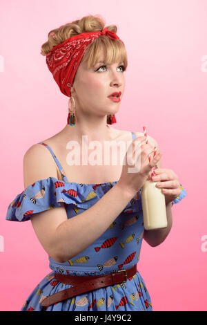 Freche Vintage Pin-up Stil Aufnahme Frau mit Flasche Milch und Strohhalme Stockfoto