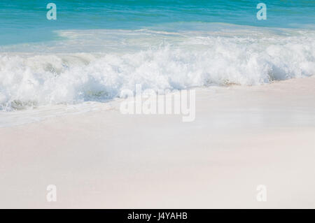 Nahaufnahme des türkisblauen Meeres mit weißen Wellen und weißen Sand auf der Karibik-Insel Aruba. Stockfoto