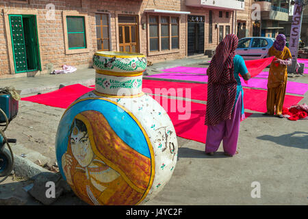 Frauen, die Trocknung des gefärbten Stoff auf einem Bürgersteig in Jodhpur, Indien Stockfoto