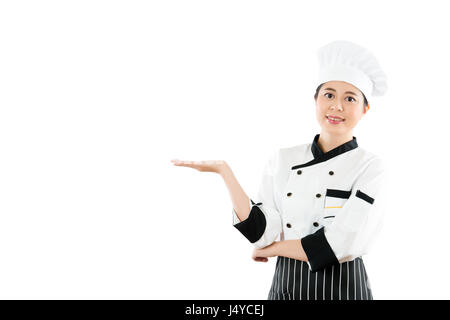 Chef-Koch oder Bäcker zeigt Ihr Produkt präsentieren. Junge asiatische Chinesin isoliert auf weißem Hintergrund. Beruf und Branche Job-Konzept. Stockfoto