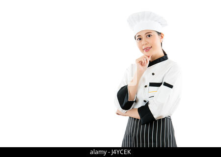 Frau Koch oder Bäcker. Glücklich stolz Porträt Frau Koch Uniform und Hut berühren ihr Kinn. Asiatische Frau Modell. isoliert auf weißem Hintergrund. professio Stockfoto