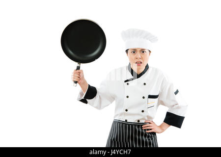 der Küchenchef des Hotelrestaurants ist wütend vor die Linse mit der Pfanne die Koch-Show gegen die Haltung in der weißen Wand Hintergrund isoliert Stockfoto