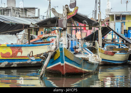 Junge sitzt in einem traditionellen Fischerboot, Sunda Kelapa Innenhafen, Jakarta, Indonesien Stockfoto