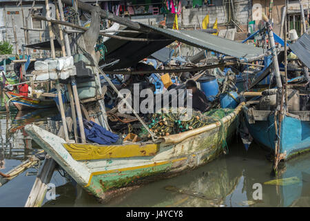 Fischer sitzt in seinem traditionellen Fischerboot, Sunda Kelapa Hafen, Jakarta, Indonesien Stockfoto