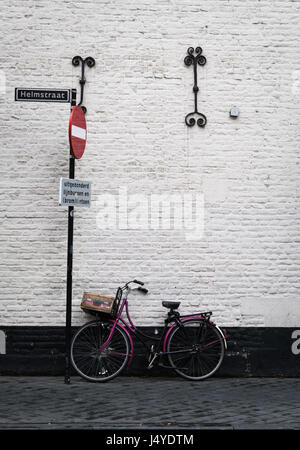 Fahrrad gelehnt gegen eine alte Mauer in der Stadt Maastricht, Niederlande (Schild "No Entry außer Busse, Fahrräder und Roller") Stockfoto