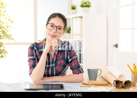 schöne junge Asiatin Architekt am Arbeitsplatz mit einem digitalen Tablet halten Bleistift während an der Rezeption im Kreativbüro Studio. Beruf eine Stockfoto