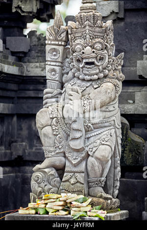 Skulpturen und Schnitzereien von Dämonen oder Götter mit Opfergaben in Ubud, Bali. Stockfoto