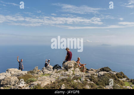 Insel Amorgos, Griechenland - Oktober 2015: Vier Wanderer Rückblick auf die Kamera, umgeben von malerischen griechischen Landschaft Stockfoto