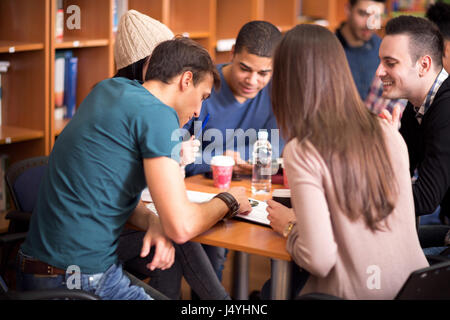 Gruppe von Studenten, die ihre Aufgabe im Team in Bibliothek Stockfoto