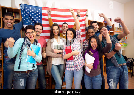 Lächelnd amerikanische Studenten präsentieren ihr Land mit Flaggen Stockfoto