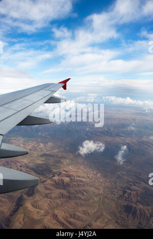 Wolken und Himmel gesehen durch Fenster eines Flugzeugs Stockfoto