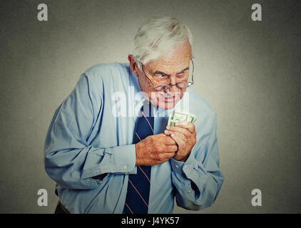 Closeup Portrait gierig leitender Angestellter, Geschäftsführer, Chef, alte Unternehmen Mitarbeiter, reifer Mann, holding-Dollar-Banknoten auf graue Wand Hintergrund isoliert. Ne Stockfoto