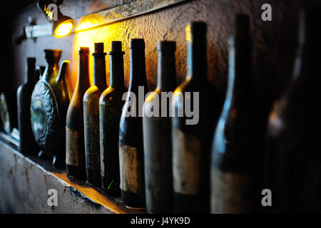 Flaschen mit alter Wein im Keller Stockfoto