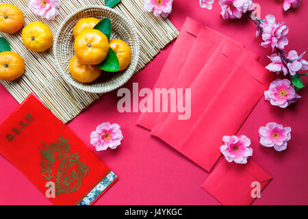 Top Zubehör Chinese New Year Festival decorations.orange,leaf,wood Warenkorb ansehen, rote Päckchen, Pflaumenblüte auf rotem Grund. Fremdsprache bedeutet Stockfoto