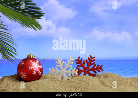 Weihnachtskugel und Ornamente an einem Sandstrand - Textfreiraum Stockfoto