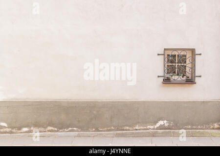 Alten verwitterten Mauer mit kleinen Fenster und eine Masse Stockfoto