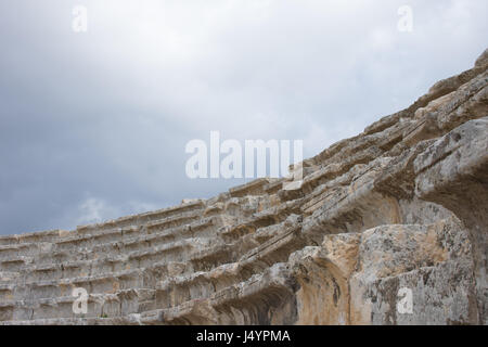 Nahaufnahme des alten geschnitzten steinernen Stufen des römischen Theaters in Jerash Jordanien. Bewölkter Himmel ist oben gesehen. Von unten fotografiert. Stockfoto