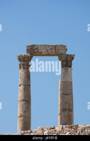 Nahaufnahme von Spalten der alten römischen Tempel des Herkules mit steinernen Balken oder Sturz auf geschnitzten Kapitellen auf der Zitadelle gegen einen tiefen blauen wolkenlosen Himmel. Stockfoto