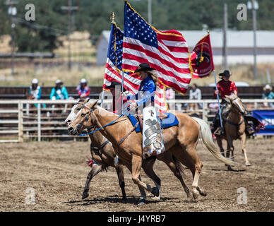 Drill Team Cowgirl reitet in die Arena an der Cottonwood-Rodeo in Kalifornien Stockfoto