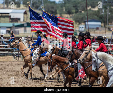 Drill Team Cowgirl reitet in die Arena an der Cottonwood-Rodeo in Kalifornien Stockfoto