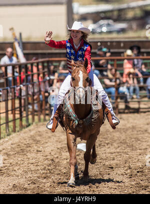 Drill Team Cowgirl reitet in die Arena an der Cottonwood-Rodeo in Kalifornien Stockfoto