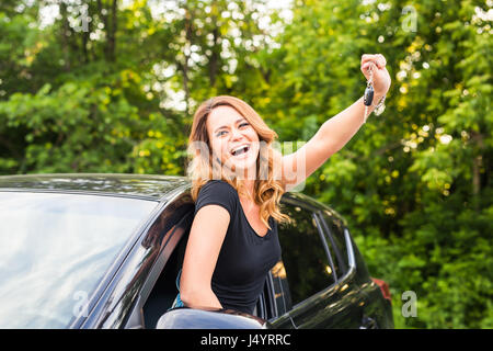 Junge Frau bekommen ihre Schlüssel im Auto. Konzept der Mietwagen oder Kauf Auto. Stockfoto