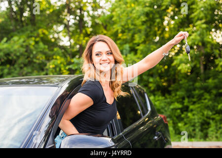 Junge Frau bekommen ihre Schlüssel im Auto. Konzept der Mietwagen oder Kauf Auto. Stockfoto