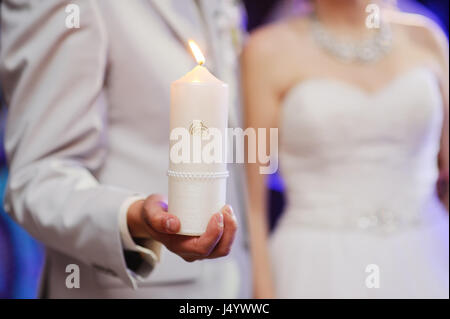 Hochzeit Kerzen in den Händen des Brautpaares Stockfoto