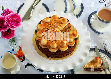 Simnel Kuchen - traditionelle Osterkuchen Obst dekoriert mit Marzipan auf einem Tisch für Tee. Stockfoto