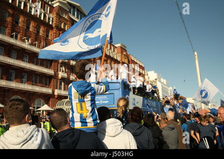 Brighton, UK. 14. Mai 2017.  Ein kleiner Junge fliegt eine Fahne mit Brighton und Hove Albion Farben drauf, beim Sitzen auf seines Vaters Schultern. Fans von Brighton und Hove Albion Football Club kam heraus in ihren Tausenden um das Team-Bus-Top Parade entlang der Stadt Küstenstraße. Mannschaft und Fans feierten Aufstieg in die Premier League. Roland Ravenhill / Alamy Live News Stockfoto