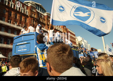 Brighton, UK. 14. Mai 2017.  Ein kleiner Junge fliegt eine Fahne mit Brighton und Hove Albion Farben drauf, beim Sitzen auf seines Vaters Schultern. Fans von Brighton und Hove Albion Football Club kam heraus in ihren Tausenden um das Team-Bus-Top Parade entlang der Stadt Küstenstraße. Mannschaft und Fans feierten Aufstieg in die Premier League. Roland Ravenhill / Alamy Live News Stockfoto