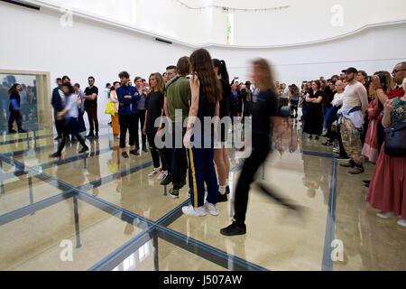 (170515)--Venedig, 15. Mai 2017 (Xinhua)--Künstler führen im Pavillon der Deutschland bei der 57. Art Biennale in Venedig, am 13. Mai 2017. Deutsche Choreografin Anne Imhof erhielt den goldenen Löwen für die beste nationale Teilnahme am 57. Art Biennale in Venedig. Für ihr Stück mit dem Titel "Faust" nach der klassischen deutschen Erzählung eines Mannes, seine Seele an den Teufel im Austausch für unbegrenzte wissen und macht verkauft, Imhof den weißen, rechteckigen Pavillon Deutschlands mit sich überschneidenden Glaswände und Böden gefüllt, und dann eine Gruppe von Darstellern in Keller gelegt. Besucher beobachten, die Stockfoto