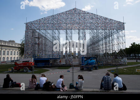 Kassel, Deutschland. 15. Mai 2017. Leute sitzen außerhalb der Documenta-Kunst arbeiten "The Parthenon of Books" Argentinische Künstlerin Marta Minujin, die im Bau in Kassel, Deutschland, 15. Mai 2017 ist. Documenta in Kassel 14 läuft vom 10. Juni 2017 bis 17. September 2017. Foto: Swen Pförtner/Dpa/Alamy Live News Stockfoto