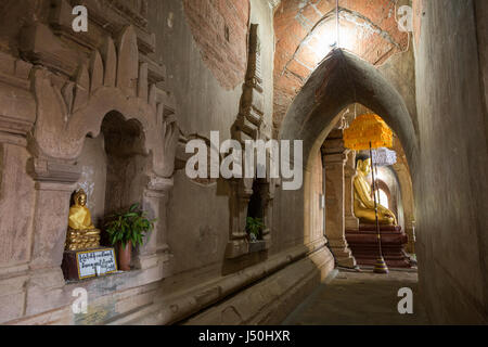 Kleine und große goldene Buddha-Statuen und Korridor im Htilominlo Tempel in Bagan, Myanmar (Burma). Stockfoto