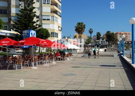 Touristen zu Fuß entlang der Promenade mit Straßencafés auf der linken Seite, Torrox Costa, Provinz Malaga, Andalusien, Spanien, Westeuropa. Stockfoto