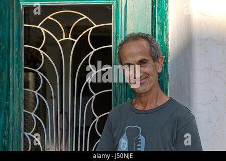 Insel Amorgos, Griechenland - Oktober 2015: Griechischer Mann vor seiner Brennerei Fabrik posiert Stockfoto