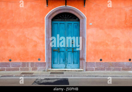 bunte blaue Tür und Orange lackiert, Hauswand, Bosa, Sardinien, Italien Stockfoto