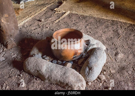 Keramiktopf auf Kohlen in einem Zelt mit Matten. Stockfoto