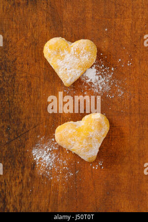 zwei Cookies auf hölzernen Hintergrund in Herzform Stockfoto