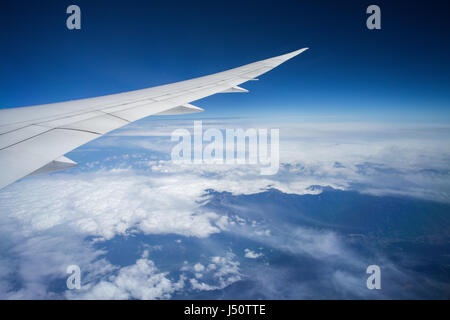 Flügel eines Flugzeugs fliegen über den Wolken Stockfoto