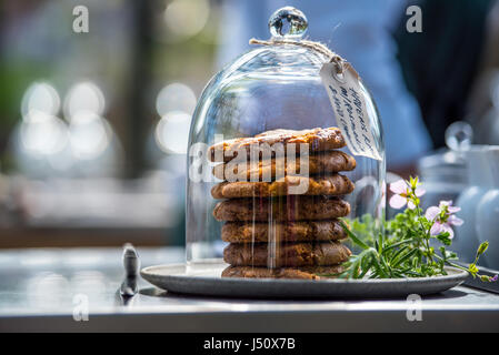 Junk-Food, kulinarisch, Backen und ungesunde Ernährung Konzept - Nahaufnahme von Cookies Schokolade und Müsli Bars in Glas im Restaurant auf einem Tisch Stockfoto