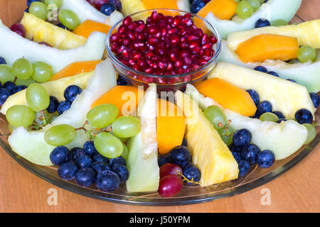 Glaswaage auf Holzboden mit gemischten frischen Früchten gefüllt Stockfoto