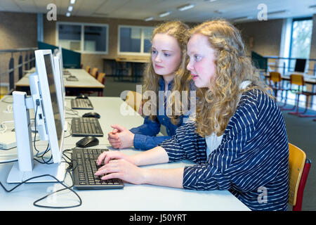 Zwei kaukasische Mädchen arbeiten am Computer im Arbeitszimmer der High school Stockfoto