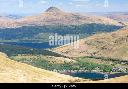 Die bewaldeten Hänge der Ben Lomond Berg steigen von den Ufern des Loch Lomond Sees hinter Arrochar Dorf in Süd-West Highlands von Schottland. Stockfoto