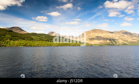 Woodland Linien Berghänge am Ufer des Loch Lomond in den westlichen Highlands von Schottland. Stockfoto