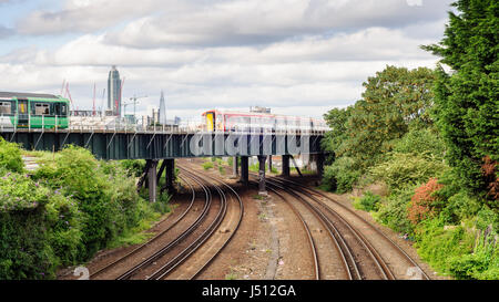 London, England, UK - 14. Juni 2014: Einen südlichen s-Bahn und Gatwick Express Zug überqueren eine Überführung in Clapham Junction im Südwesten L Stockfoto